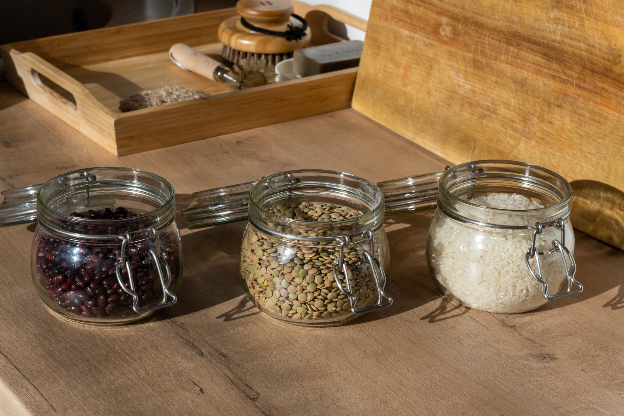 Bocaux de lentilles, haricots et riz sur une table en bois