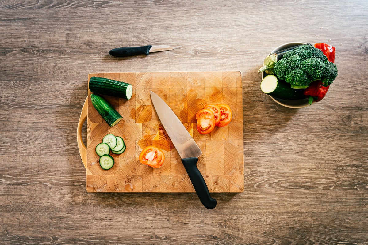 Legumes frais en cours de decoupe sur une planche en bois
