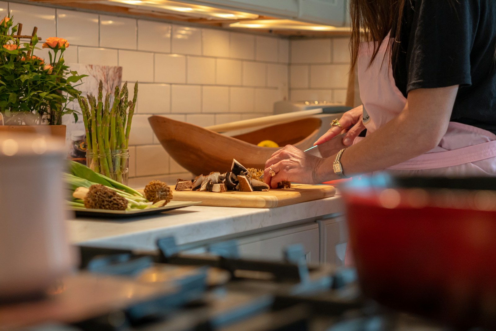 Personne découpant des légumes sur une planche dans une cuisine